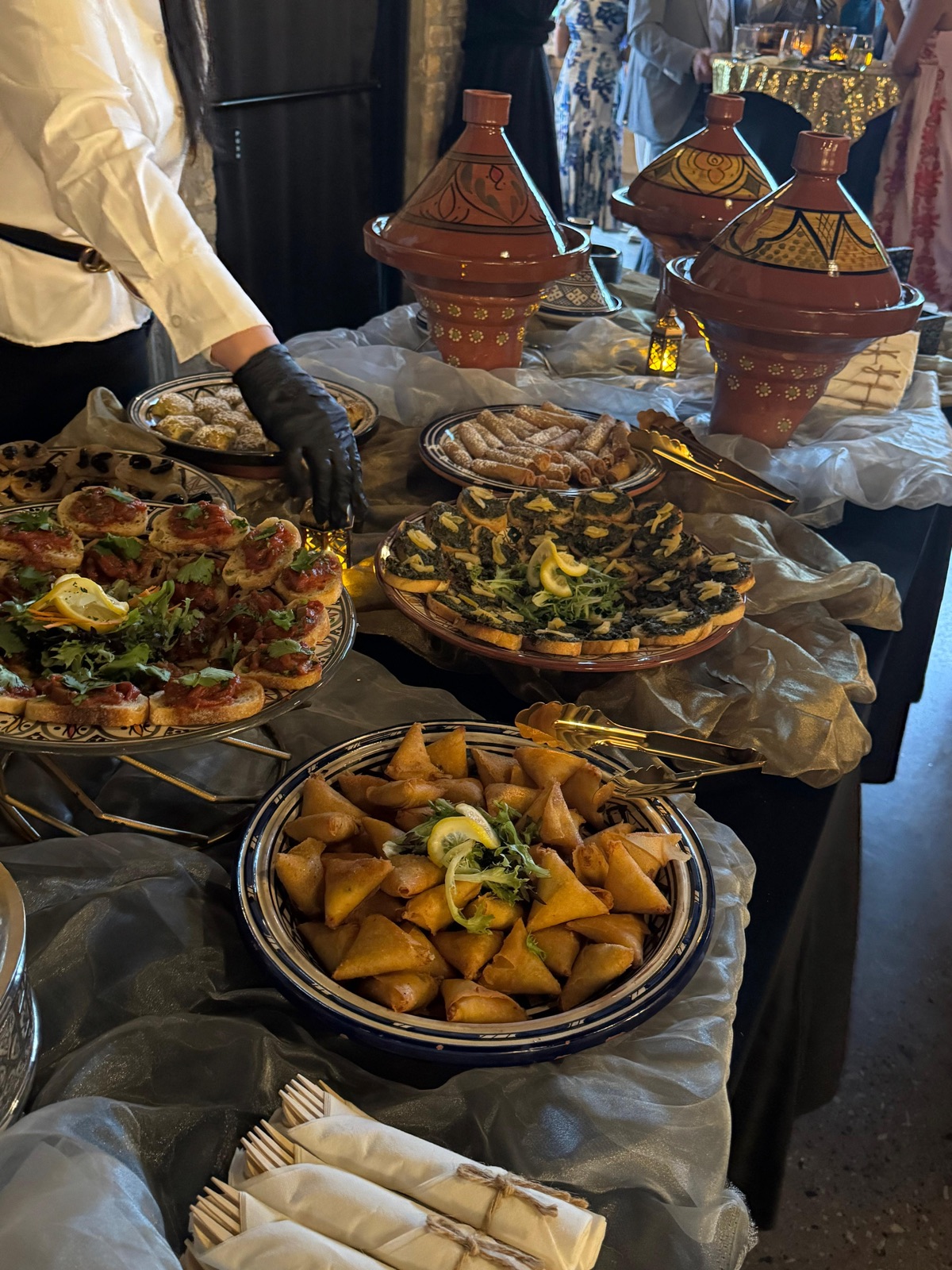 Moroccan wedding catering display with tagines and appetizer platters